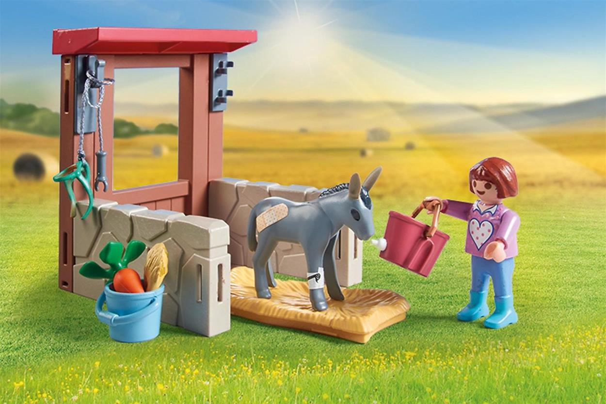 A lány a Playmobil készletből Állatorvosi kirándulás a szamarakhoz egy szamarat gondoz