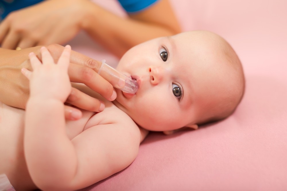 Az első fogacskához szilikon ujjra húzható fogkefét használunk a tisztításhoz Babák fogmosása