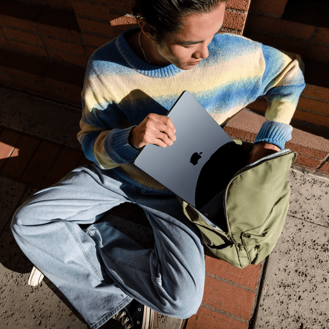 Egy ember elölnézetből, ahogyan egy 15 hüvelykes MacBook Airt rak a táskájába